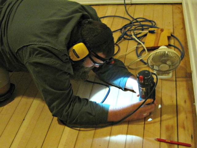 The first step in repairing the hole in our hardwood floor was to remove the jagged edges and prep the hole for a plug. Man using roto zip tool: Repair hole in hardwood floor tutorial